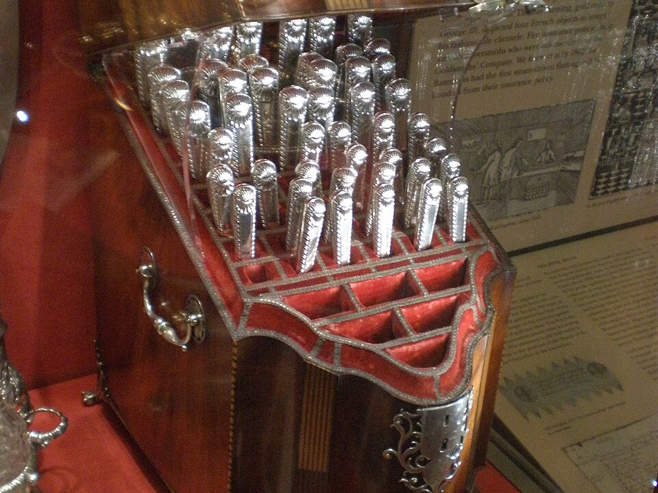 Estuche con una colección ornamentada de cubiertos antiguos de plata